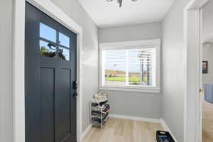 Doorway to outside with baseboards and wood finished floors