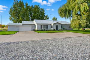 Single story home with concrete driveway, a front lawn, and a garage