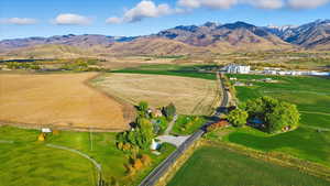 Aerial view of property and surrounding area featuring mountains and rural landscape