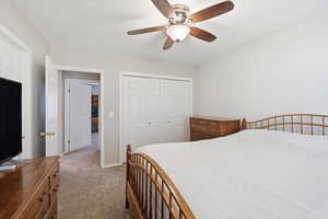 Bedroom featuring light colored carpet, a closet, and ceiling fan