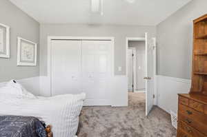 Bedroom featuring light carpet, a closet, and ceiling fan