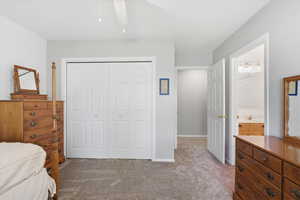Bedroom featuring a closet, light colored carpet, and ceiling fan