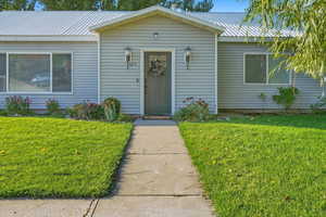 Bungalow featuring a metal roof and a front yard