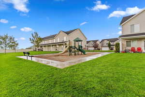 Community jungle gym with a lawn and a patio area