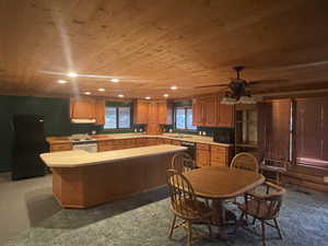 Kitchen featuring wood ceiling, light countertops, brown cabinets, a kitchen island, and black appliances