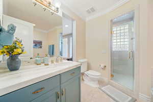 Bathroom with ornamental molding, a stall shower, vanity, and light tile patterned flooring