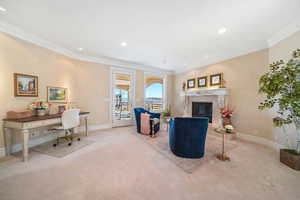 Office space with ornamental molding, a high end fireplace, recessed lighting, and carpet