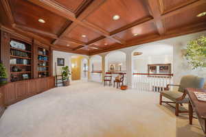 Sitting room with light colored carpet, coffered ceiling, a wood ceiling with exposed beams, crown molding, and recessed lighting