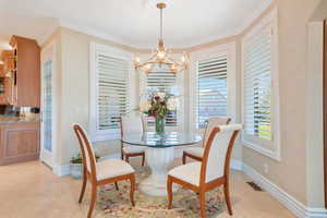 Dining space featuring ornamental molding and a chandelier