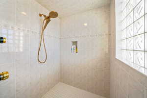 Full bath featuring tiled shower