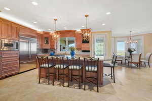Kitchen featuring a breakfast bar area, a chandelier, a center island, recessed lighting, and crown molding