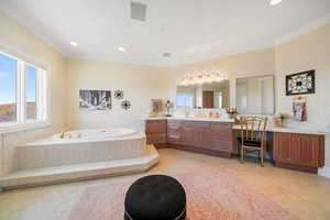 Bathroom with vanity, a bath, recessed lighting, crown molding, and light tile patterned flooring
