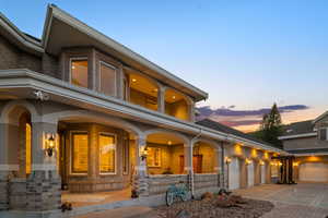Exterior space featuring brick siding, driveway, a porch, and an attached garage
