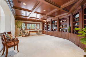 Living area featuring coffered ceiling, crown molding, light colored carpet, recessed lighting, and a wood ceiling with exposed beams