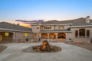 Mediterranean / spanish house featuring covered porch, a shingled roof, brick siding, and curved driveway
