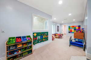 Playroom with ornamental molding, carpet floors, and recessed lighting