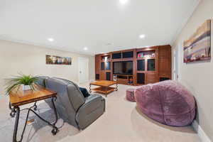 Carpeted living room with crown molding and recessed lighting