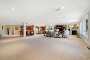 Living area with light carpet and recessed lighting