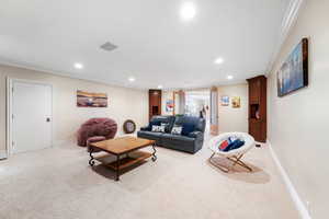 Carpeted living room with crown molding and recessed lighting