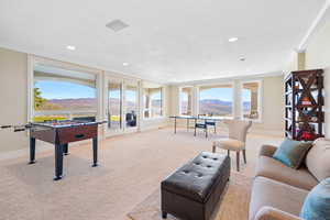 Playroom with crown molding, light carpet, a mountain view, and recessed lighting