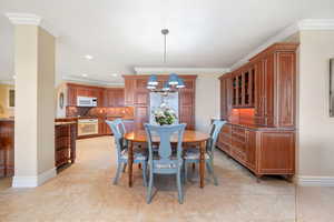 Dining area featuring crown molding, recessed lighting, a chandelier, and light tile patterned floors