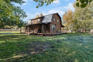 Rear view of house featuring a gambrel roof, a metal roof, a chimney, and log siding