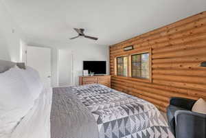 Bedroom with rustic walls and ceiling fan