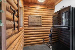 Stairs featuring rustic walls and wood ceiling