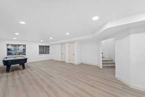 Basement featuring stairs, light wood-style floors, and recessed lighting