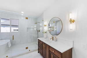 Bathroom with vanity, a stall shower, a freestanding tub, recessed lighting, and light marble finish flooring