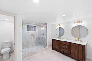 Bathroom featuring double vanity, a shower stall, and recessed lighting