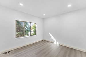 Empty room featuring recessed lighting and light wood-type flooring