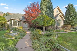 View of front of property featuring stone siding, a front lawn, and stucco siding