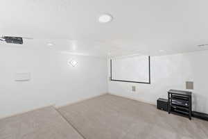 Cinema room featuring a textured ceiling, light colored carpet, and recessed lighting