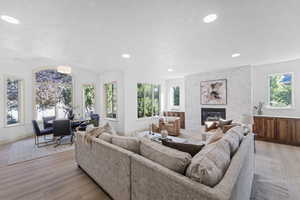 Living area with a fireplace, light wood-style flooring, and recessed lighting