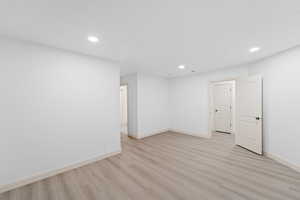 Below grade area featuring light wood-style flooring and recessed lighting