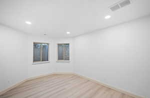 Empty room with light wood-style flooring and recessed lighting