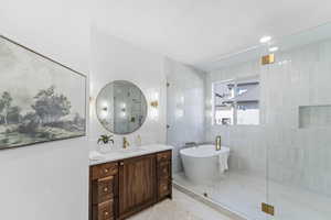 Full bathroom featuring vanity, a freestanding bath, a stall shower, and recessed lighting