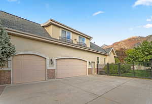 View of front of home with stucco siding, concrete driveway, and a mountain view