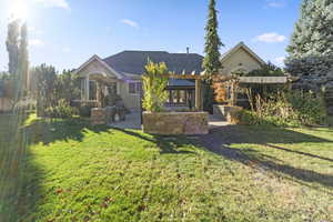 View of front of home with stucco siding, a patio area, a pergola, and a front yard