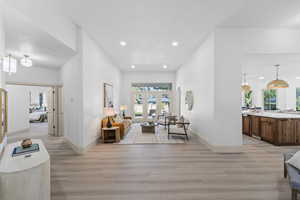 Living room with light wood-type flooring, plenty of natural light, french doors, and recessed lighting