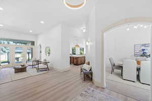 Interior space featuring arched walkways, light wood finished floors, and recessed lighting