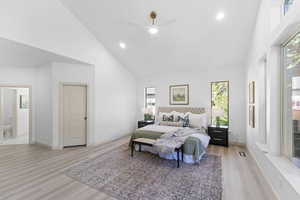 Bedroom with high vaulted ceiling, light wood-type flooring, ceiling fan, and recessed lighting