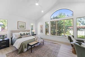 Bedroom with high vaulted ceiling, multiple windows, light wood-style flooring, recessed lighting, and a ceiling fan