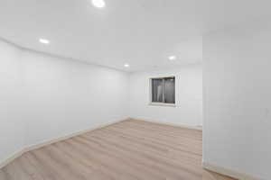 Empty room with light wood-type flooring and recessed lighting