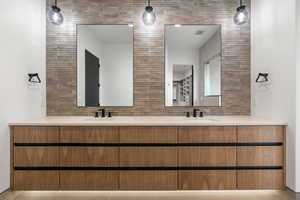 Full bathroom featuring decorative backsplash, double vanity, and tile walls