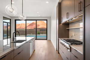 Kitchen with modern cabinets, stainless steel appliances, recessed lighting, pendant lighting, and light wood-type flooring
