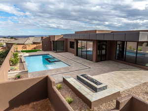 View of pool with an outdoor fire pit, a patio, a fenced backyard, and a pool with connected hot tub