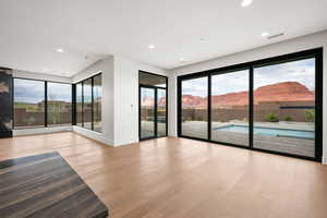 Unfurnished living room featuring a mountain view, light wood-style floors, recessed lighting, and plenty of natural light