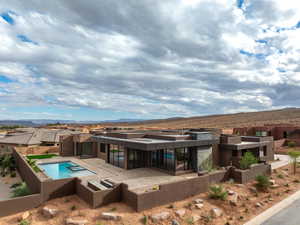 Rear view of house with a fenced backyard, an in-ground hot tub, a mountain view, and a patio